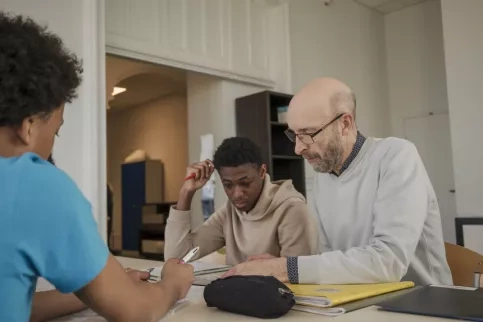 Bénévole aidant les jeunes de l'IES Saint-Philippe avec leurs devoirs